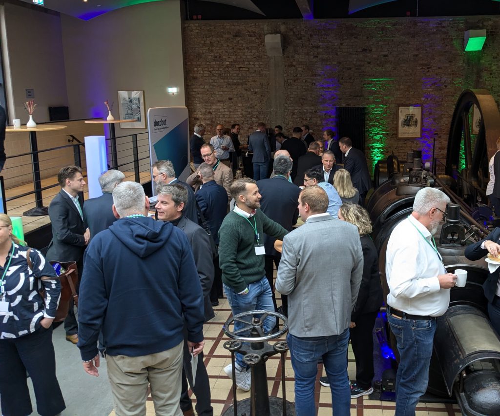 Menschen, die sich in einer Industrieumgebung während einer Veranstaltung unterhalten und interagieren.