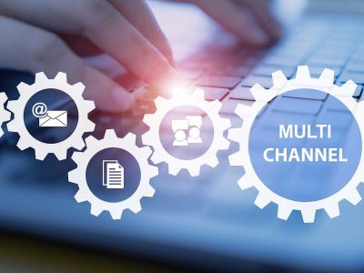 Grafik mit Zahnrädern und Symbolen für Multikanalversand auf einer Tastatur.